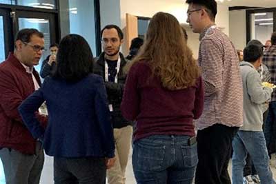 A group of people talking at FSU-ORNL Workshop